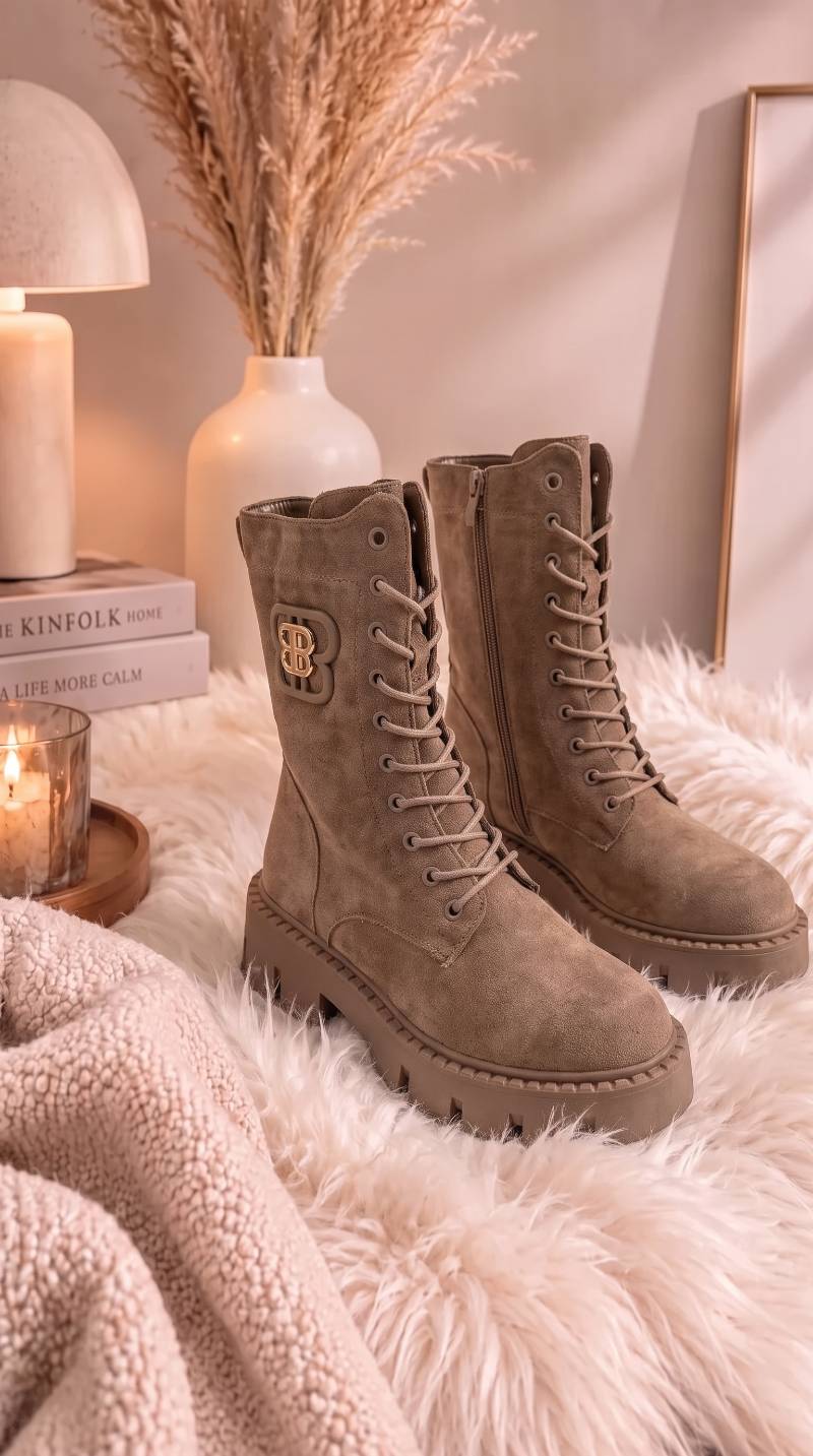 Schnürboots aus Velours mit Plateau-Sohle und goldenem Logo-Detail, seitlich auf Fell drapiert in Taupe