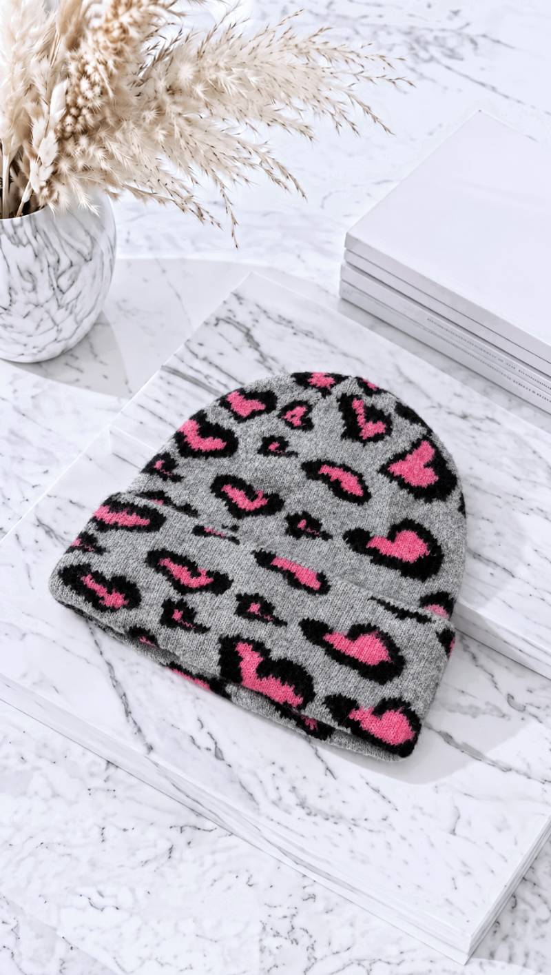 Graue Strickmütze mit pink-schwarzem Leopardenmuster auf Marmoruntergrund